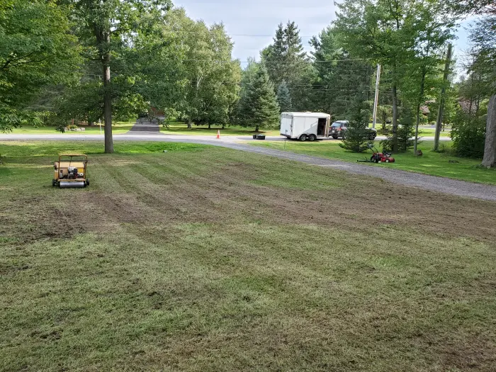 Commercial core aerator working across a large lawn, aeration passes visible