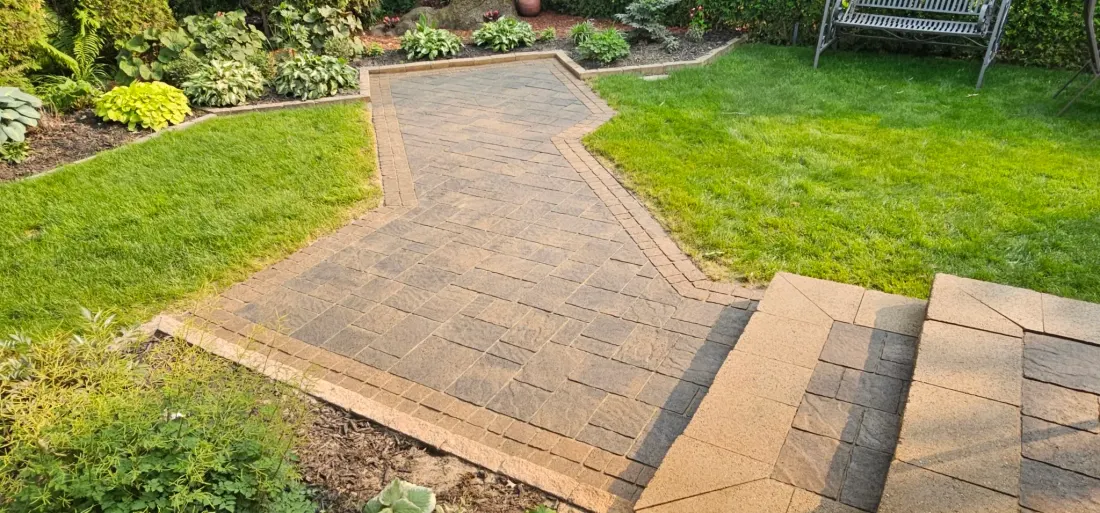 The same S-curve walkway from the same angle after CAT5 — rich brown and charcoal satin colour