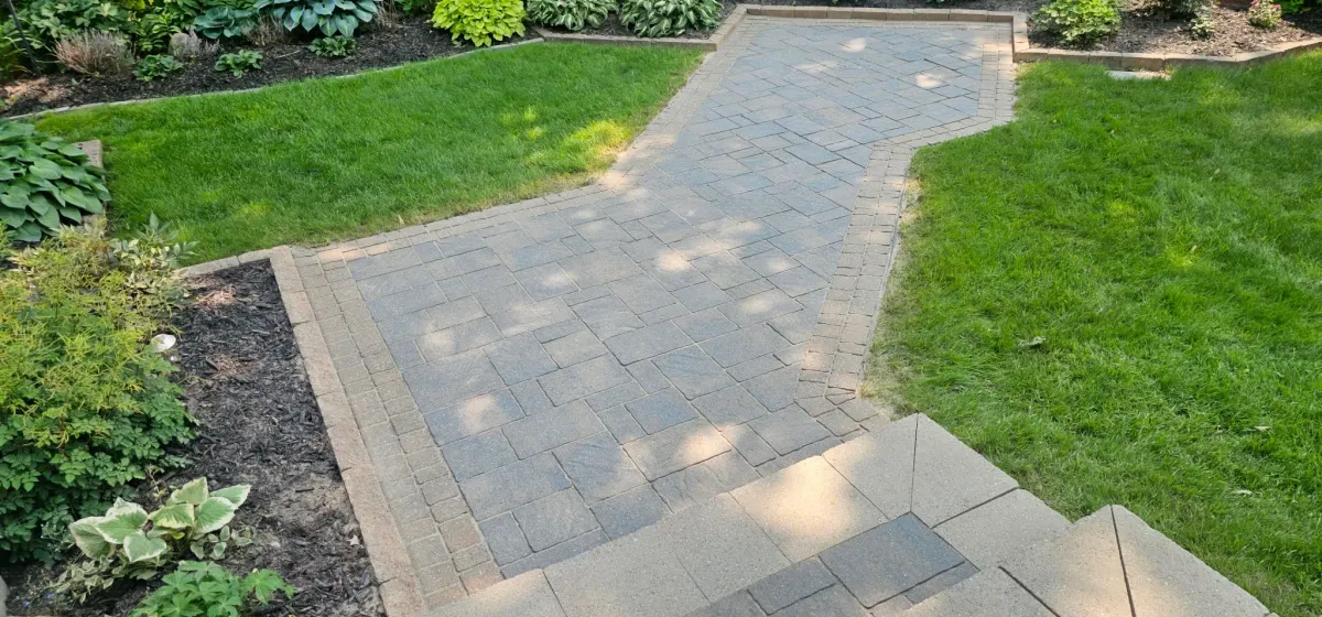 Allée de jardin en pavé uni restaurée et resablée, mais non scellée