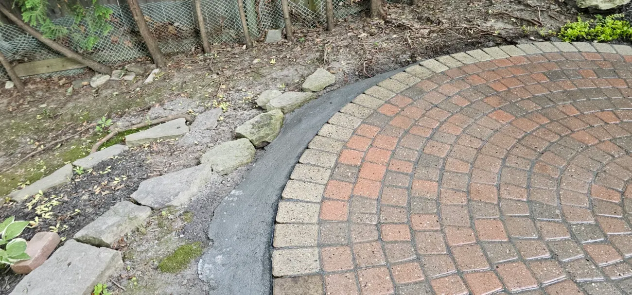 Freshly troweled concrete edge restraint locking circle-border pavers
